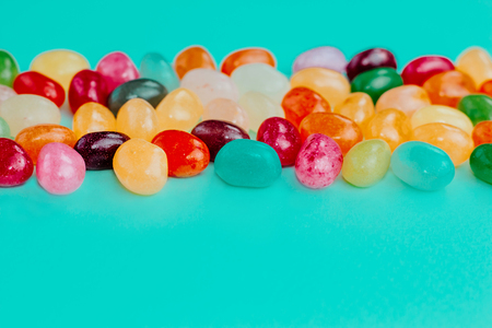 Colorful bean sweet candies on bright turquoise blue background. Easter concept. Close up. Copy space.の写真素材