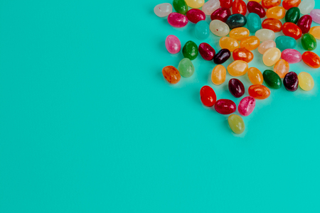 Top view of colorful bean sweet candies on bright turquoise blue background. Easter concep. Copy space.の写真素材