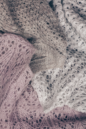 Piled stylish knitted pastel colored sweaters in different knitting patterns. Winter and spring season knitwear clothing.の写真素材