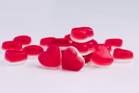 Pile of heart shaped red and white jelly sweets on white background for Valentines Day celebration. Place for text.の写真素材