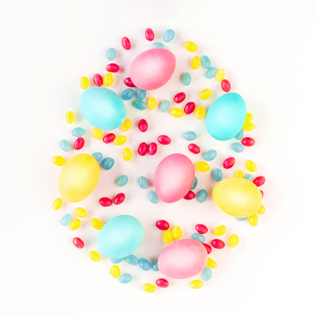 Colorful Easter egg concept. Easter eggs and candies on isolated white background. Flat lay.の写真素材