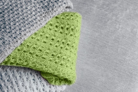 Pile of stylish knitted pastel colored sweaters and one in trendy color of spring and summer 2019. Top view. Copy space.の写真素材