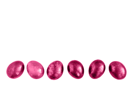 Pink Easter eggs in a row on isolated white background. Flat lay. Copy space.の写真素材