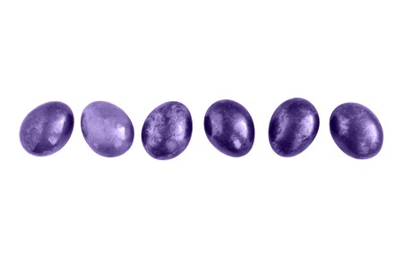 Ultraviolet Easter eggs in a row on isolated white background. Flat lay. Copy space.の写真素材