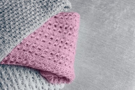 Pile of stylish knitted pastel colored sweaters and one in trendy color of spring and summer 2019. Top view. Copy space.の写真素材