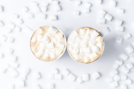 Romantic cozy desk top with two cups of coffee with marshmallows on marble table. Top view. Space for text .の写真素材