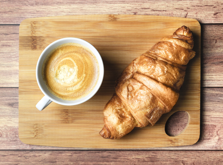 Perfect breakfast of croissant and coffee on wooden table. Rustic style. Top view.の写真素材
