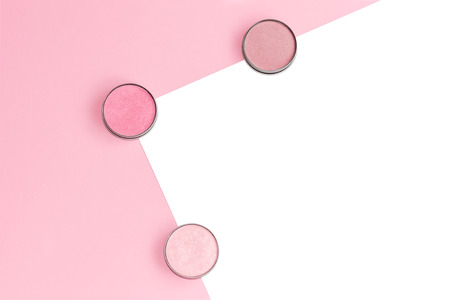 Pink, beige and ivory blushes, eyeshadows or highlighters on pink and isolated white background. Flat lay. Copy space.の写真素材