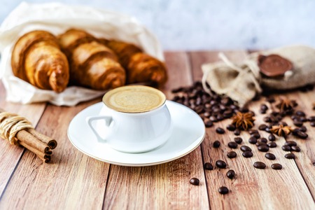 Perfect breakfast of croissants and coffee with milk on wooden table. Rustic style. Close-up.の写真素材