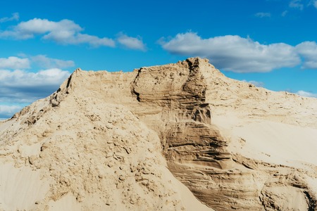 Industrial sand quarry. Sand pit. Construction industry. Sand hill agains the blue sky.の写真素材