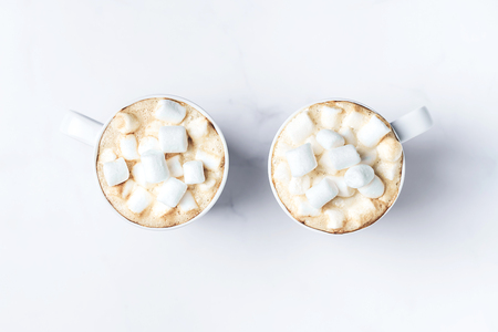 Romantic cozy desk top with two cups of coffee with marshmallows on marble table. Top view. Space for text .の写真素材
