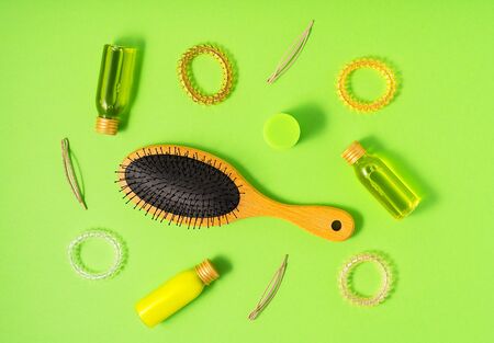 Hair care products and styling items on green background. Flat lay style. Women beauty and beauty salon cosmetics concept.の写真素材