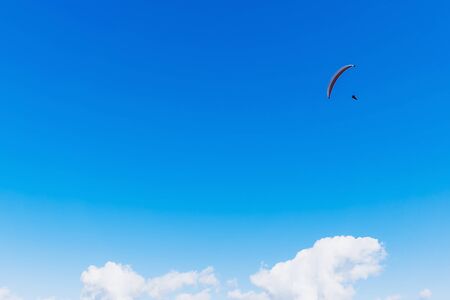 Paraglider flying over the mountains on a bright summer day. Paragliding sport concept. Copy space.の写真素材