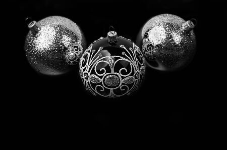 Trendy Christmas silver and black balls decor on isolated black background. Christmas backdrop for your design. Close-up.の写真素材