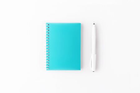 Top view of light blue cover spiral notepad with pen on white desk background. Mockup for your design. Flat lay.の写真素材