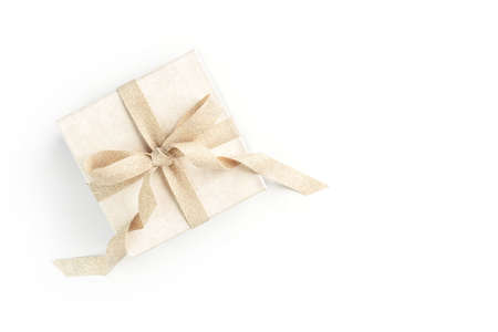 Beautiful present box with elegant golden bow on isolated white background. Festive backdrop for...