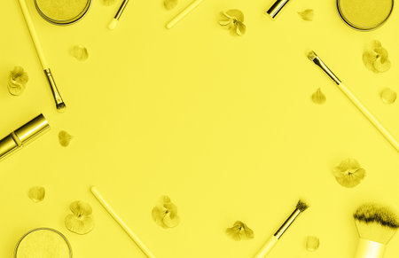 Flat lay composition with decorative makeup products and flowers toned in trendy yellow color. Flat lay style. Color 2021 concept. Copy space.の写真素材