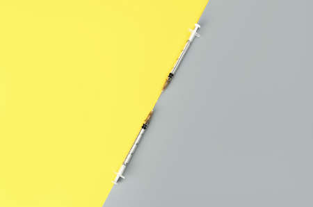 Syringes on trendy yellow and grey background. Cosmetology and medicine background. vaccine concept....