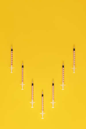 Syringes on trendy yellow background. Cosmetology and medicine background. vaccine concept. Top...