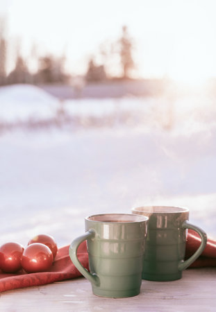 Vintage rustic card with green porcelain cups of tea on white wooden table decorated with red Christmas balls. Winter seasonal holiday background. Food and drink concept. Closeup.の写真素材