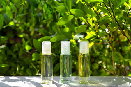 Cosmetic display on green leaves and natural stone backdrop. Natural cosmetics and beauty concept....