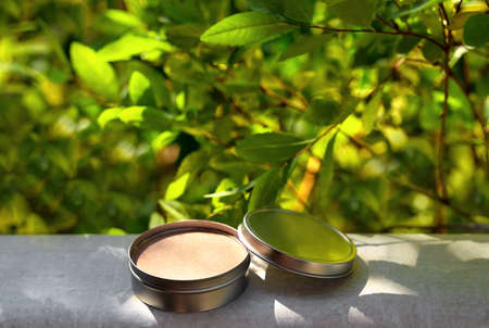 Cosmetic display on green leaves and natural stone backdrop. Natural cosmetics and beauty concept....