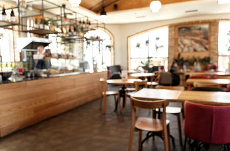 Blurred Italian restaurant background in vintage style. Restaurant interior with the chef at the counter and customers. Defocused background for your design. Restaurant lifestyle concept.の写真素材