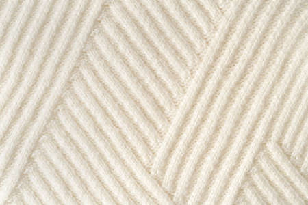 Pastel knitted fabric with visible geometric knitted pattern. Fall and winter concept. Flat lay...