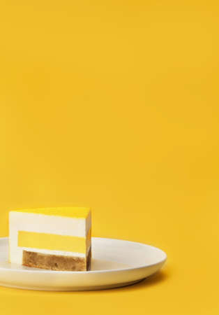 Delicious mango and passion fruit mousse cake slice with the layers and texture displayed on bright...