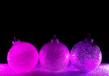Abstract neon purple and pink gradient glitter glass Christmas baubles background with copy space. Christmas and New Year concept.の写真素材