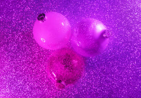 Abstract neon purple and pink gradient glitter with Christmas glass baubles. Color gradient glow background for your design. Christmas and New Year concept in flat lay style. Copy space.の写真素材