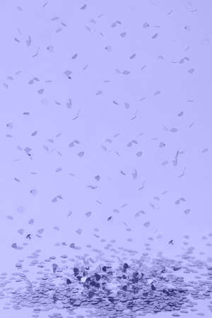 Falling shiny heart shaped confetti. Toned in trendy color of year 2022. Great backdrop for any holiday or event with copy space.の写真素材