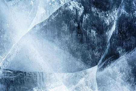 Transparent dark blue ice of frozen Baikal lake with white cracks pattern. Beautiful winter nature...