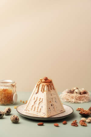 Traditional Easter cottage cheese dessert Paskha decorated with caramel, nuts, raisins and quail...