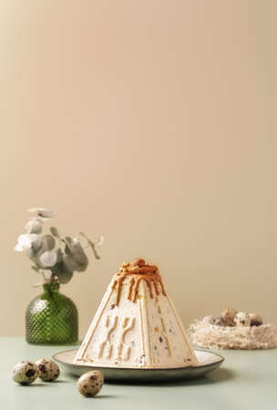 Traditional Easter cottage cheese dessert Paskha decorated with caramel, nuts and quail eggs on...