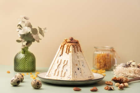 Traditional Easter cottage cheese dessert Paskha decorated with caramel, nuts, raisins and quail...