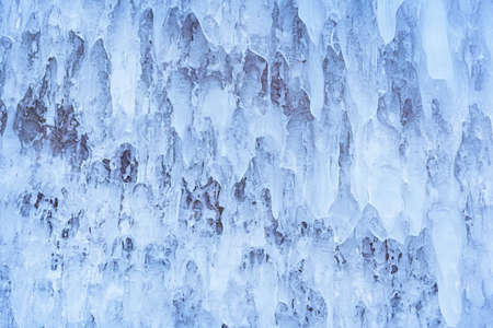 Blue ice and icicles on the rocks of Ogoy island, Baikal lake, Siberia, Russia. Abstract winter nature background with copy space.の写真素材