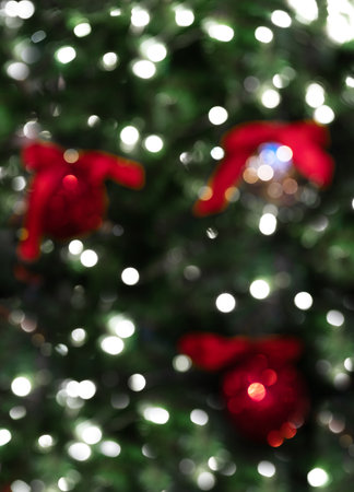 Blurred image of beautiful fir tree decorations and lights of traditional Christmas fair. Holidays...