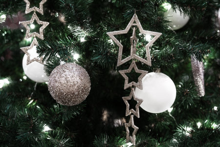 Beautifully decorated and illuminated Christmas tree with white and silver decoration. Holiday...