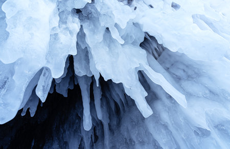 Blue ice and icicles on the rocks of Ogoy island, Baikal lake, Siberia, Russia. Abstract winter...