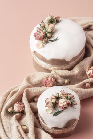 Glazed Easter cakes decorated with dry tea rose flowers on pastel background. Easter composition...