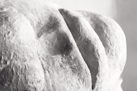 A fragment of plaster human head sculpture against grey background. Close-up face crop with copy space.の写真素材