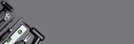 Flat lay composition with set of home repair tools on dark grey background. Top view pattern with...