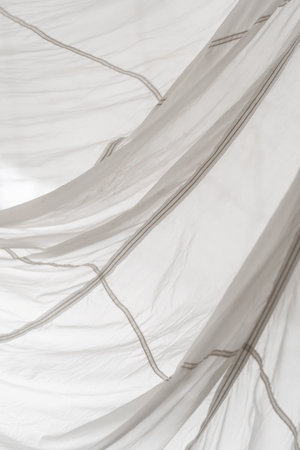 Segment of folded white parachute fabric closeup. Monochrome background with copy space for your design.の写真素材