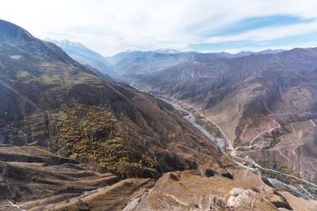 Ravine, winding river, and towering snow-capped mountain peaks. Natural background.の写真素材