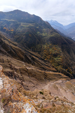 Panorama of a precipice, deep canyon, picturesque green terraced fields and snowy mountain peaks. Natural background.の写真素材