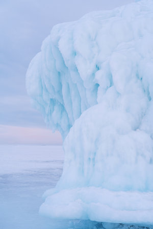 Beautiful winter landscape with blue ice cave grotto and frozen clear icicles. Lake Baikal, Russia....