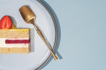 A slice of strawberry bento cake featuring lemon sponge and creamy filling, elegantly presented on a...