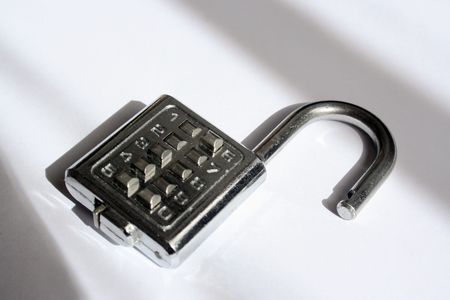 Combination lock unlocked with shadows appearing like jail or prison barsの写真素材