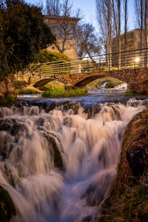 A waterfall lit up at night running through a town.の写真素材
